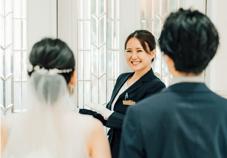 ブライダルプランナーが花婿と花嫁を誘導している写真